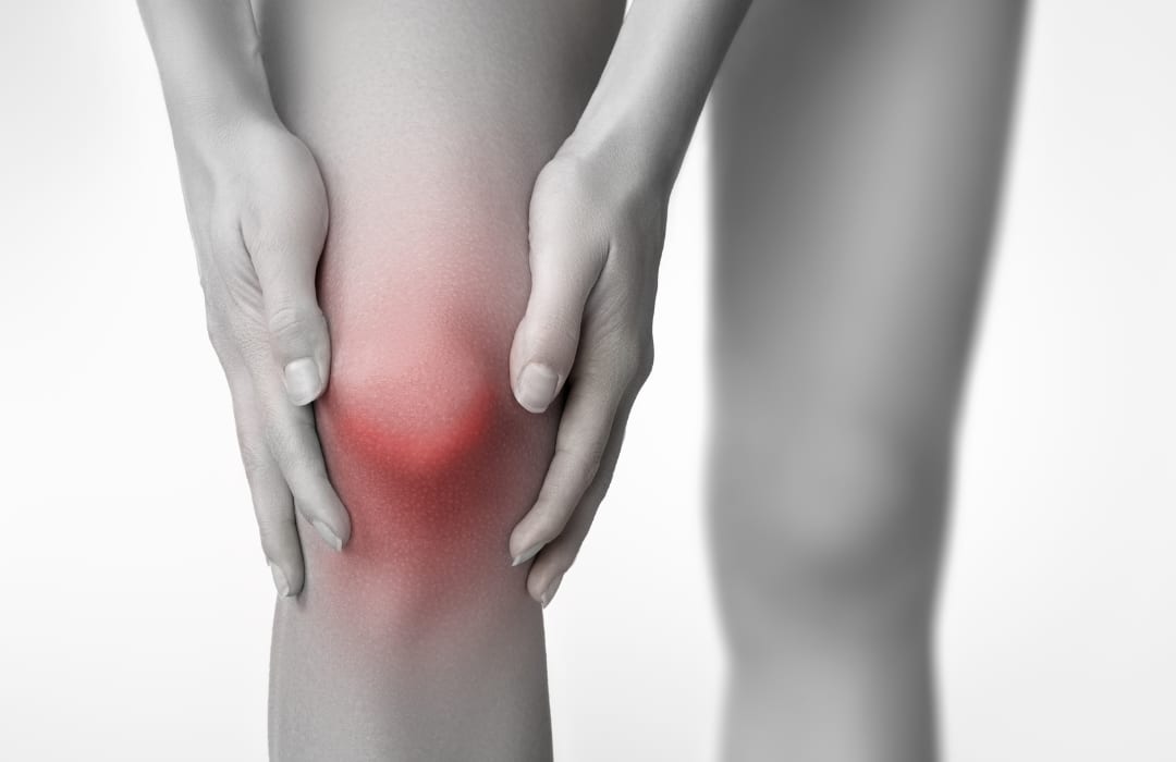 Person holding their knee in discomfort, illustrating that regular exercise is the antidote to arthritis
