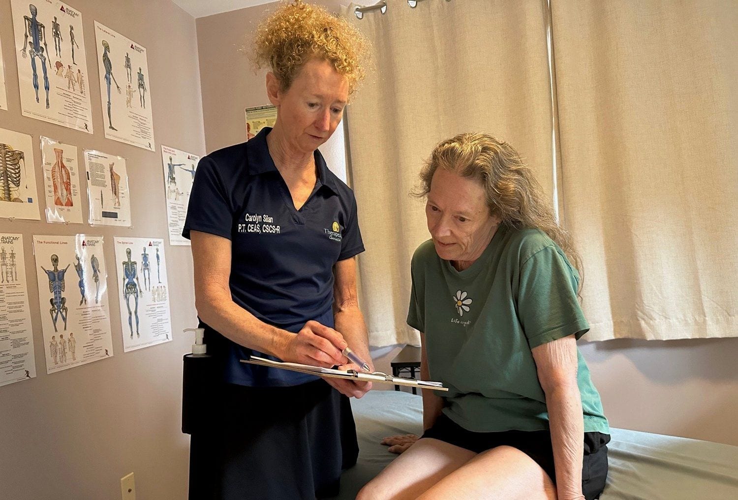 Carolyn Silan performing an orthopedic assessment with a clipboard