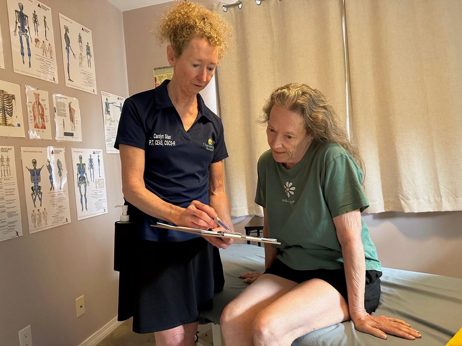 Therapist with a clipboard performing an orthopedic assessment