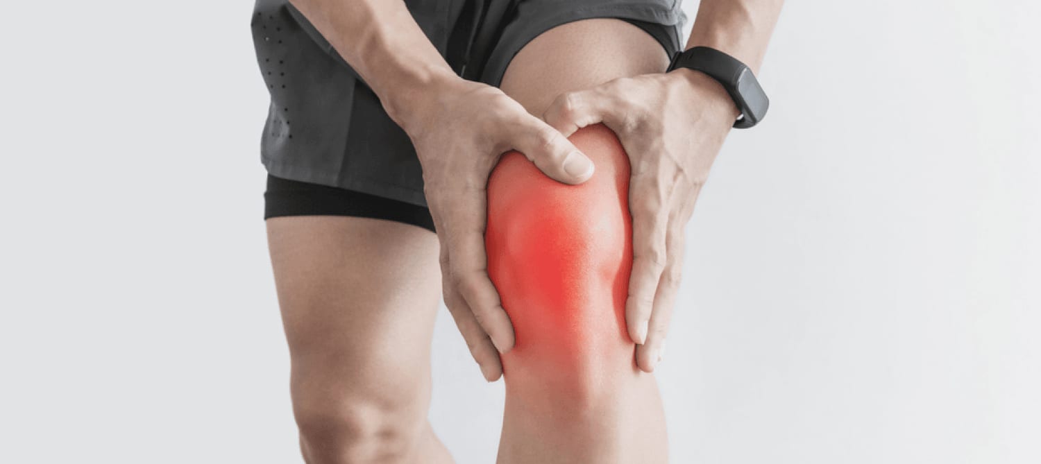 Person holding their knee, indicating pain