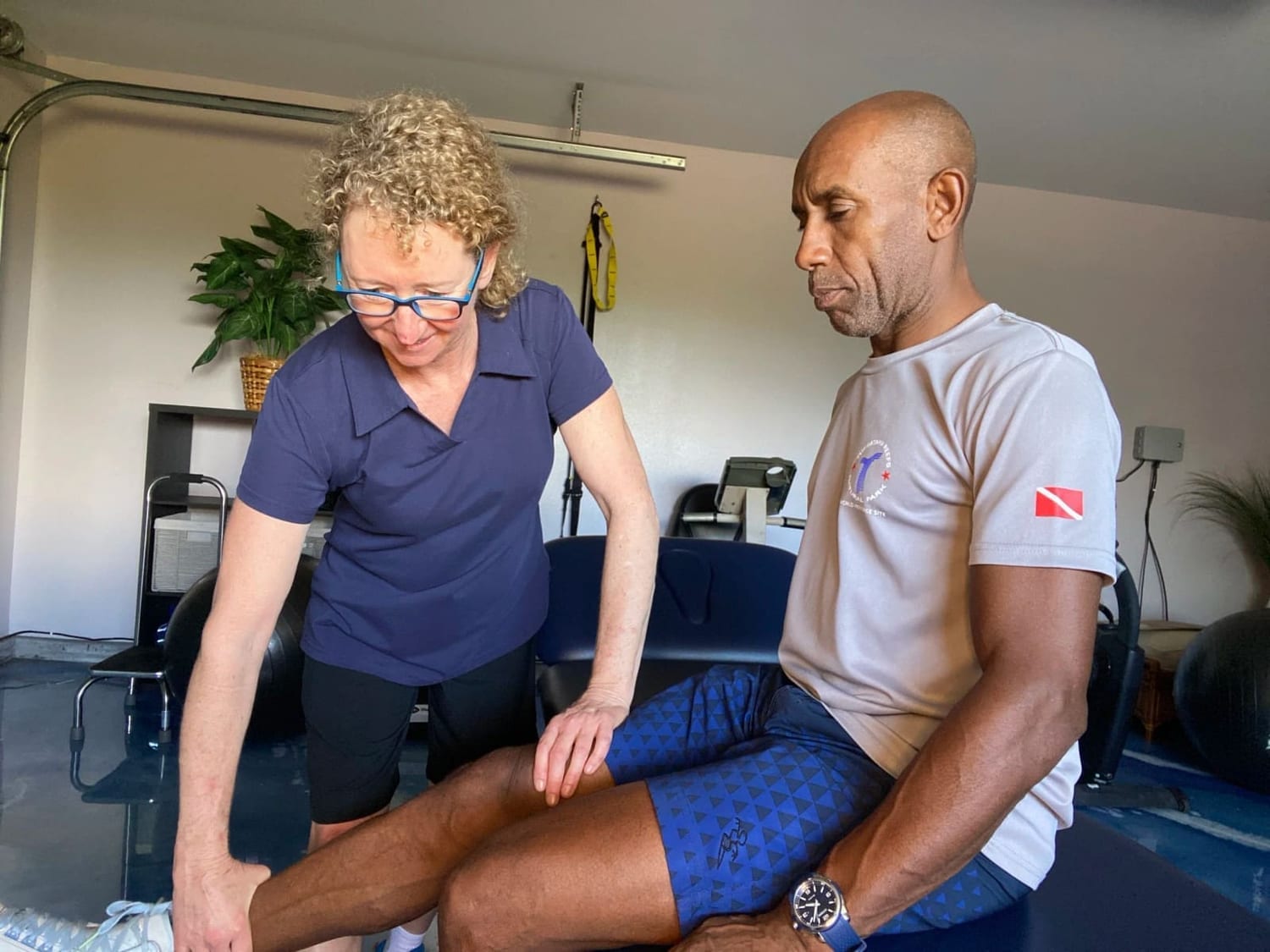 Carolyn Silan assessing an athlete's knee in the studio
