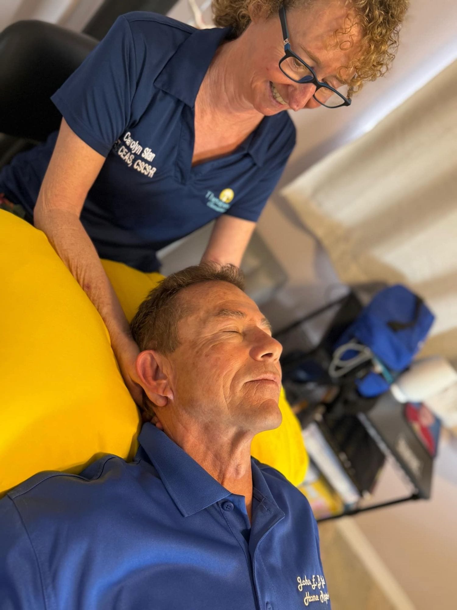 Carolyn Silan gently cradling a client's head and neck during a hands-on session