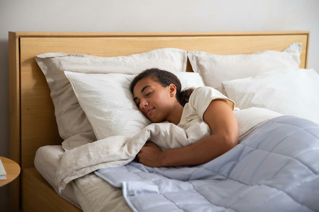A woman sleeping comfortably in a bed with white pillows