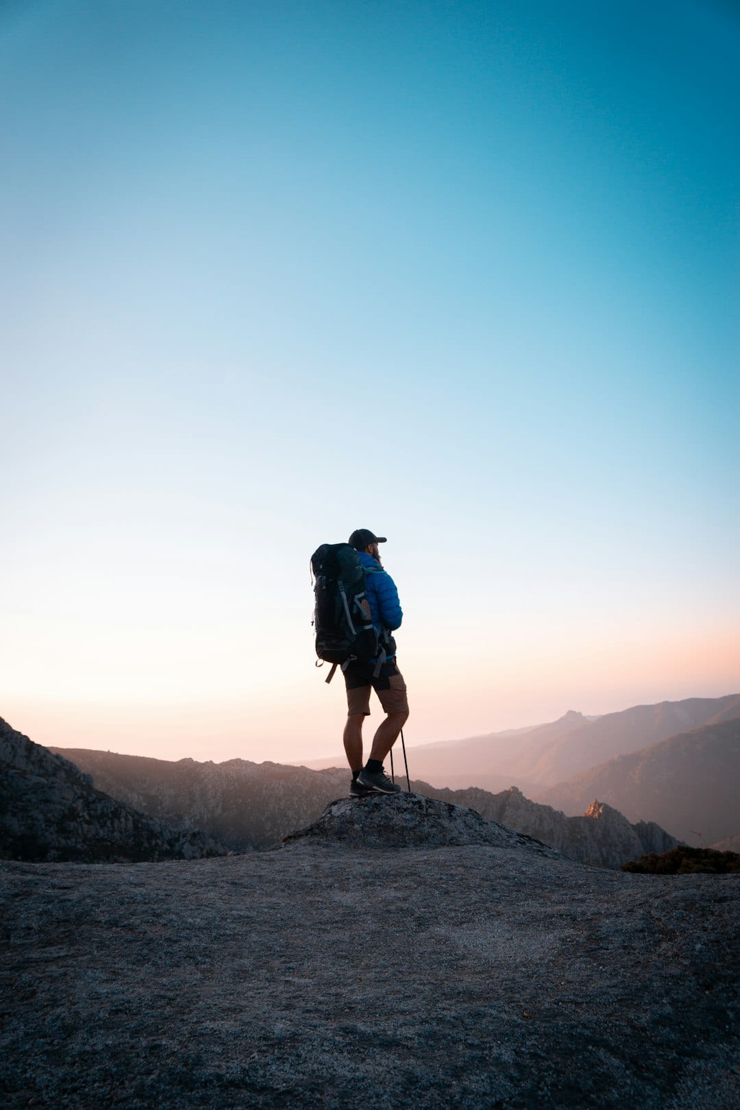 A hiker with a backpack on a ridge at sunrise